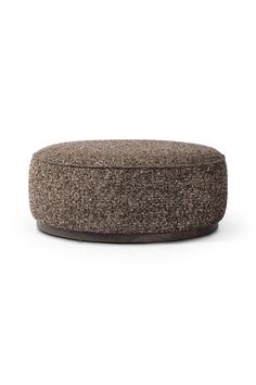 a round ottoman sitting on top of a white floor