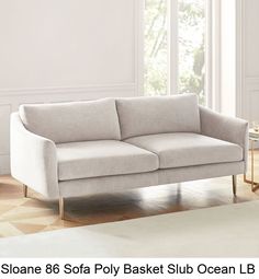 a white sofa sitting on top of a hard wood floor