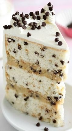 there is a piece of cake with chocolate chips on the top and one slice has white frosting