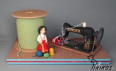 a doll sitting on top of a table next to a sewing machine and spool of thread