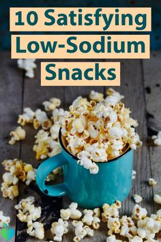 a blue mug filled with popcorn sitting on top of a wooden table