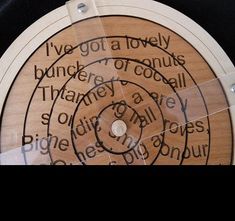 a close up of a wooden disc with writing on it