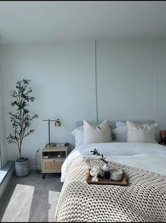 a white bed sitting next to a window with lots of pillows on top of it