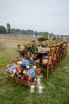 an outdoor table set up with flowers and candles