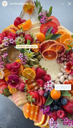 a cake decorated with fruit and flowers on top of a table