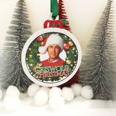 a christmas ornament hanging from the side of a tree with ornaments around it