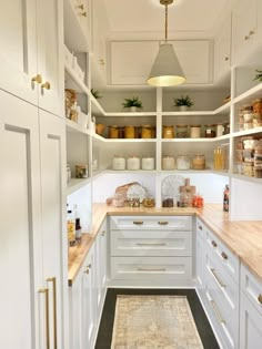 a kitchen with white cabinets and wooden counter tops, along with an area rug on the floor