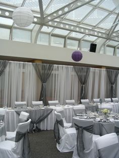 a banquet room set up with white and gray linens