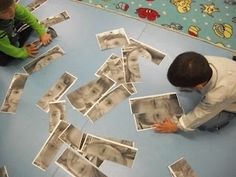 two young boys are playing with pictures on the floor