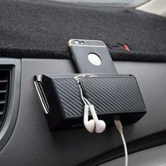 an electronic device is plugged into the car's air freshener system with earbuds