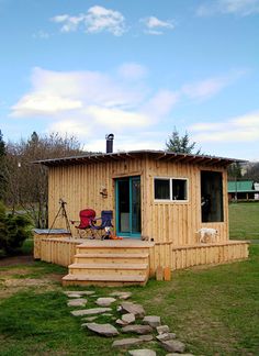 a small wooden cabin sitting on top of a lush green field