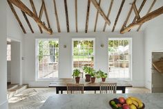 a table with fruit on it in front of two windows