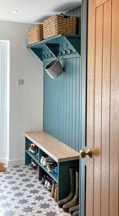 a mudroom with blue walls and shelves filled with shoes, buckets and baskets