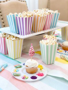 a table topped with cupcakes covered in frosting next to other desserts