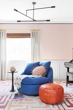 a living room with pink walls and blue furniture