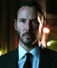 a man in a suit and tie looking at the camera with an intense look on his face