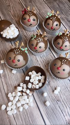 cupcakes decorated with reindeer faces and marshmallows are on the table