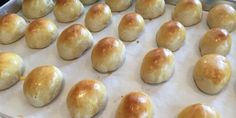 freshly baked bread rolls are lined up on a baking sheet and ready to go into the oven