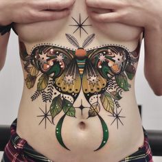 a woman's stomach with tattoos on it