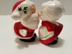 two ceramic figurines of santa claus kissing each other