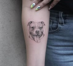 a woman's arm with a small tattoo of a pitbull on it