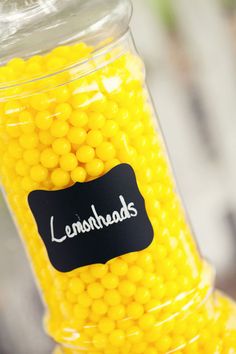 a jar filled with yellow candies sitting on top of a table