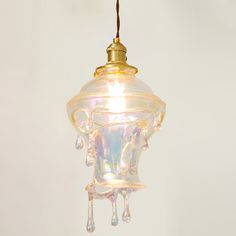 a glass light hanging from a ceiling with water droplets on the top and bottom of it