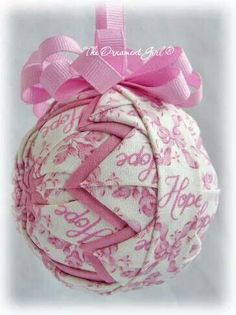 a pink and white ornament hanging from a ribbon