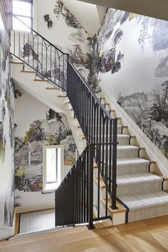 a staircase with wallpaper and railings leading up to the second floor in a home