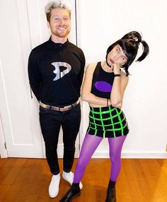 two people standing next to each other on a hard wood floored room with white walls