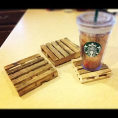 a cup of coffee sitting on top of a table next to some wooden coasters