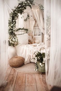 a bedroom with white curtains and flowers on the bed, next to a teddy bear