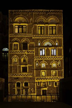 an old building lit up at night with windows and balconies on the side