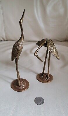 two bronze colored metal bird figurines sitting on top of each other