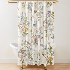 a shower curtain with flowers on it and a white bathtub in the foreground