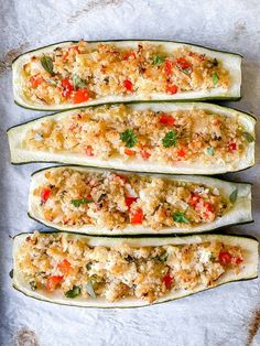 four stuffed zucchini boats with toppings on them sitting on a baking sheet