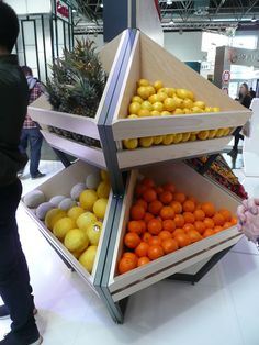 three tiered fruit stand with oranges, lemons and pineapple