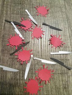 some scissors are laying on the table with red paint splattered all over them