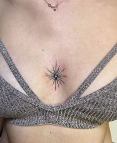 a woman's chest with a small star tattoo on her left side ribcage