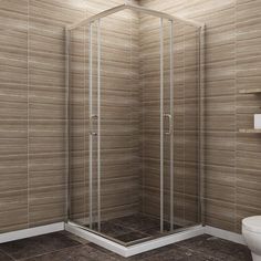 a bathroom with a walk in shower next to a white toilet and brown tiled walls