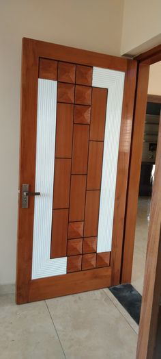 a wooden door with white and brown panels on the outside wall, in front of a beige tiled floor