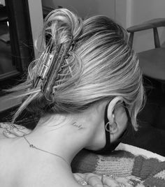 the back of a woman's head with ear piercings