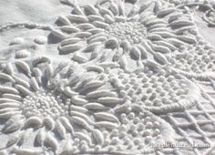 an embroidered tablecloth with white flowers on the top and bottom, is shown in close up