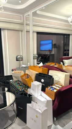 a living room filled with lots of furniture and boxes on top of each other in front of a flat screen tv