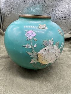 a blue vase with flowers painted on it