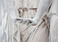 the statue is white and has hands extended out to touch each other's hand