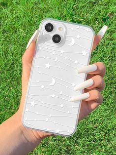 a person holding an iphone case in their hand with white nails on it and stars and moon designs