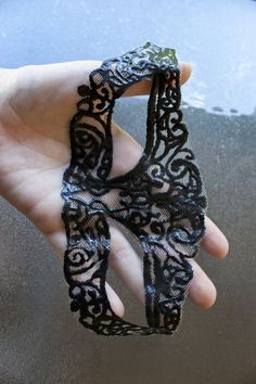 a hand holding a piece of black lace