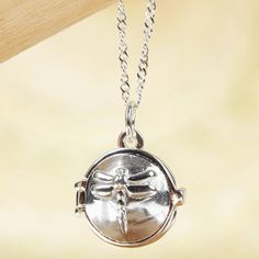 A dragonfly graces this locket necklace protecting your precious keepsake within. Perfect for a tiny photo or lock of hair the locket is cast from sterling silver by Mexican artisan Katherine Satizabal. The pendant centers a classic cable chain. Adjustable Charms Necklace For Keepsake, Dainty Silver Locket Necklace With Round Pendant, Silver Dainty Locket Necklace With Round Pendant, Dainty Sterling Silver Round Locket Necklace, Adjustable Round Pendant Locket Charm Necklace, Adjustable Nickel-free Locket Necklace Gift, Sterling Silver Necklace With Lobster Clasp For Keepsake, Adjustable Keepsake Pendant Locket Necklace, Silver Dainty Locket Necklace For Keepsake