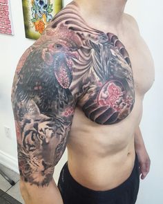 a man with a tiger tattoo on his arm and chest is posing for the camera